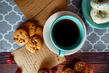 Mesa intelectual con café, galletas y pastelillos.