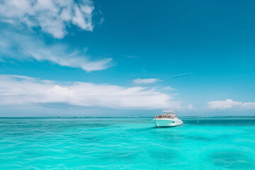Fototapeta na wymiar Motor boat in turquoise ocean water against blue sky with white clouds and tropical island. Summer vacation, tropical beach with turquoise water, summer holidays vacation. generative ai