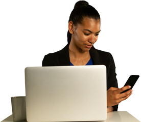 Woman using smartphone while using laptop