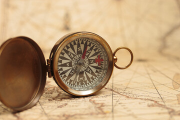 Fototapeta na wymiar Magnetic compass on a world map. Travel, geography, navigation concept background.