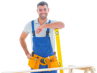 Smiling carpenter in overalls with spirit level