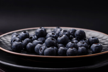 Delicious fresh blueberries on a textural black concrete background