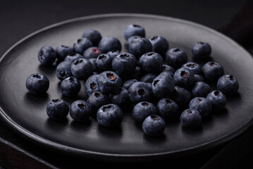 Delicious fresh blueberries on a textural black concrete background