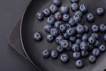 Delicious fresh blueberries on a textural black concrete background