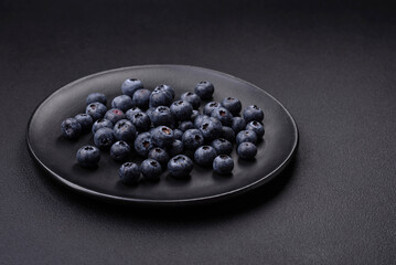 Delicious fresh blueberries on a textural black concrete background
