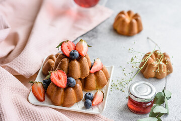 Delicious cupcakes or muffins with raisins and nuts, strawberries and blueberries
