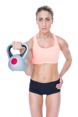 Serious female crossfitter lifting kettlebell 