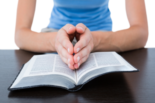 Woman praying while reading bible