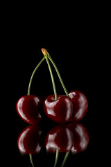 Red cherries on a white background with reflection. Fresh cherries on a black background.
