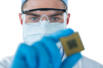 Doctor in protective glasses and surgical mask holding electronic chip