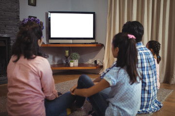 Family watching television together in living room