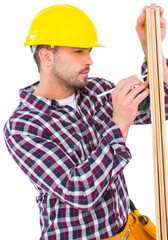 Handyman using measure tape to mark on wooden plank