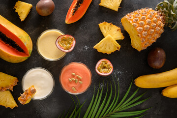 Indian fruits lassi . Pineapple, papaya lassi or smoothie in glasses on black background. Popular...