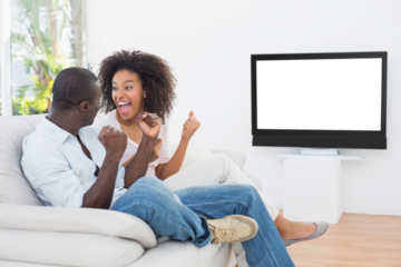 Couple sitting on couch together watching tv