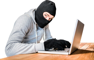 Focused thief with hood typing on laptop