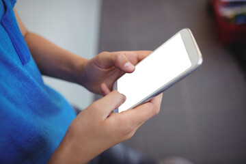 Schoolboy using mobile phone in corridor at school