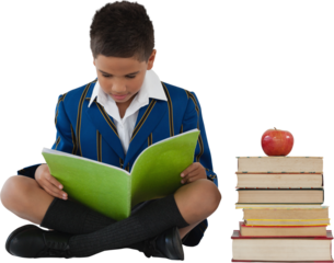 Schoolboy studying by stack of books and apple