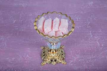 Turkish delight, Turkish delight, on a crystal glass plate. Pink wooden background. Still life,...