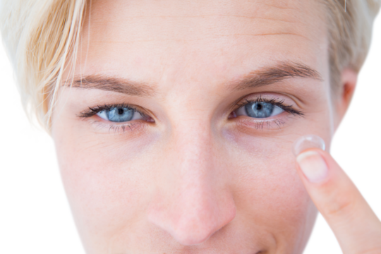 Pretty blonde applying contact lens - Powered by Adobe