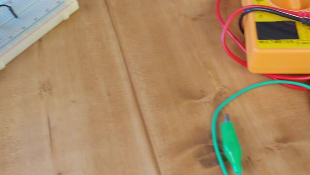 Breadboard with electrical elements, on a wooden table.