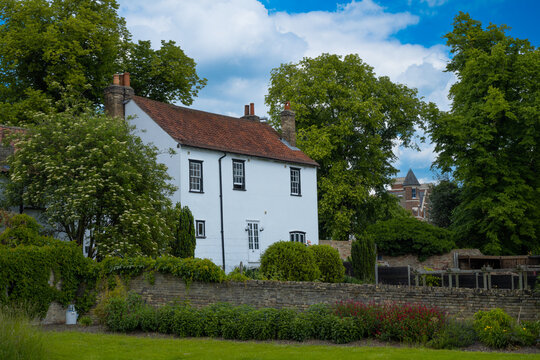 White house with traditional British architecture in front of garden in Cambridge England