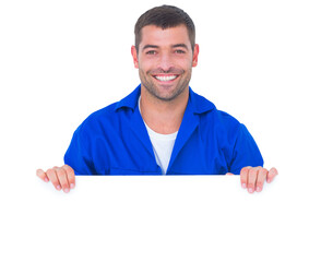 Handsome mechanic holding blank placard