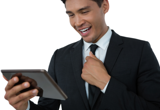 Happy businessman holding necktie while using tablet computer