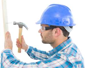 Carpenter hammering nail on wooden plank