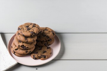 chocolate chip cookies, chocolate chip cookies on wooden table, chocolate chip cookies on a pink plate on a white wooden table