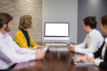 Business team looking at computer screen in meeting room