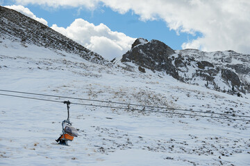 Wyciąg narciarski, kolej linowa wysoko w ośnieżonych górach wiezie narciarzy na szczyt.