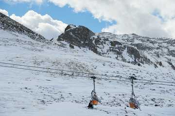 Wyciąg narciarski, kolej linowa wysoko w ośnieżonych górach wiezie narciarzy na szczyt.