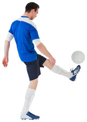 Football player in blue kicking ball