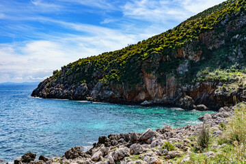 Fototapeta na wymiar Beautiful views of the turquoise sea surrounded by huge rocky walls and mountain vegetation.