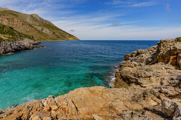 Fototapeta na wymiar Beautiful views of the turquoise sea surrounded by huge rocky walls and mountain vegetation.