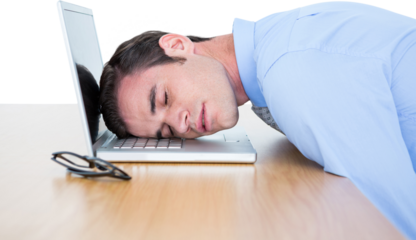 Exhausted businessman resting head on laptop