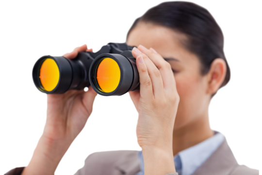 Brunette businesswoman looking through binoculars