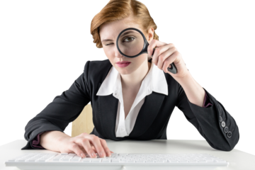 Redhead businesswoman looking through magnifying glass