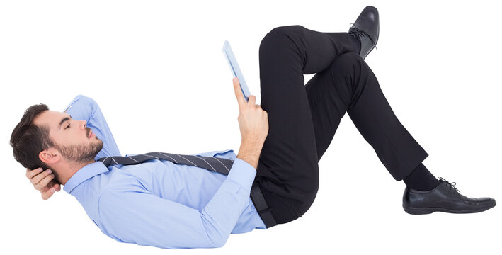 Businessman lying on floor using tablet 
