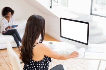 woman using a computer with a cup of coffee