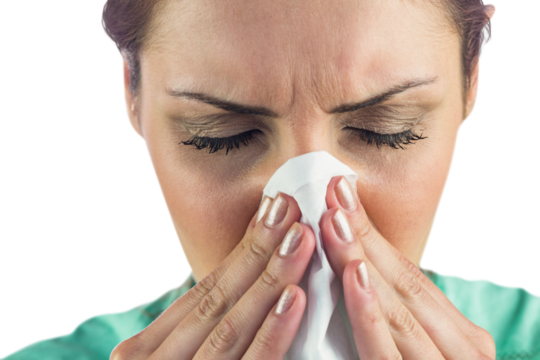 Woman suffering from cold with tissue on nose