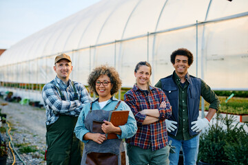 Team of confident farmers at garden center looking at camera.
