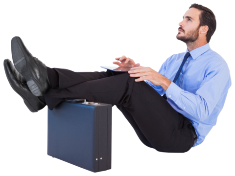 Businessman sitting with feet up while using his tablet