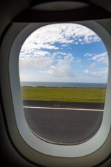 Photo from the plane window, ocean and sky, runway view.