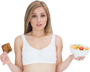 Portrait of young woman holding cookie and fruit bowl