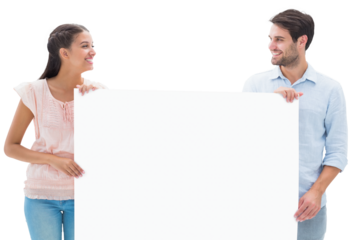 Attractive young couple smiling and holding poster