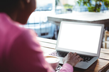 Woman using laptop in cafe