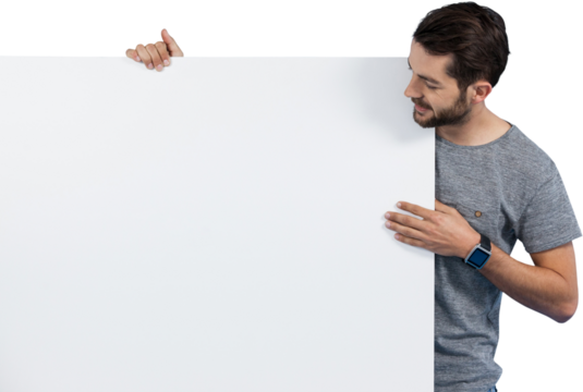 Smiling young man holding placard against white background