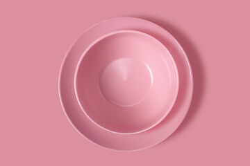 Two pink plates on a pink background. View from above. Concept