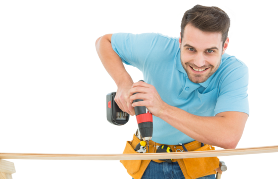 Smiling construction worker using hand drill on wooden plank